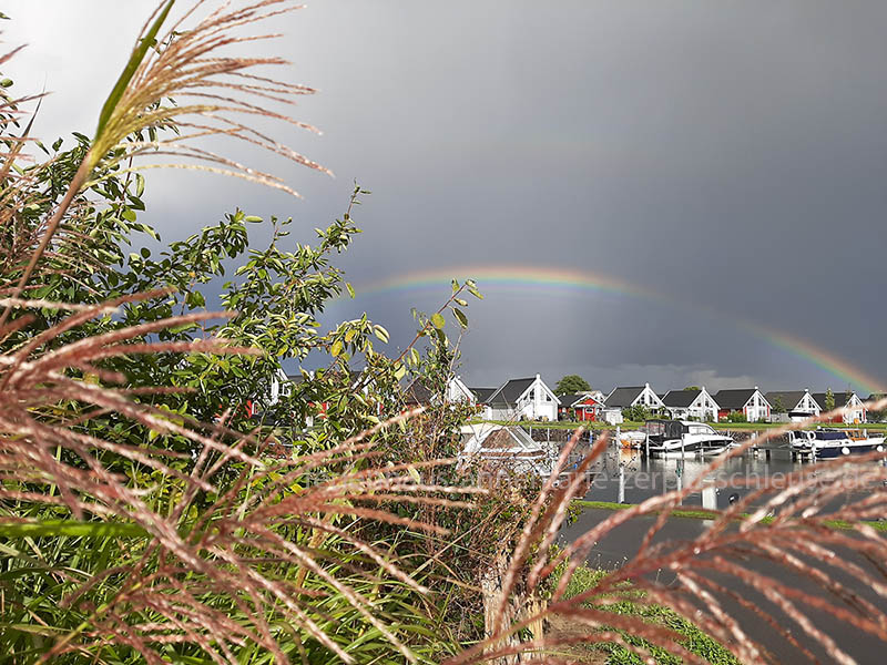 Häuser am Hafen im Hintergrund ein Regenbogen